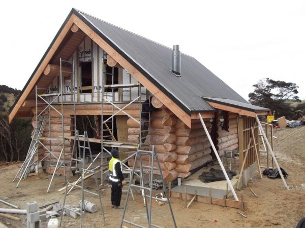Log cabin under construction with roof and scaffolding